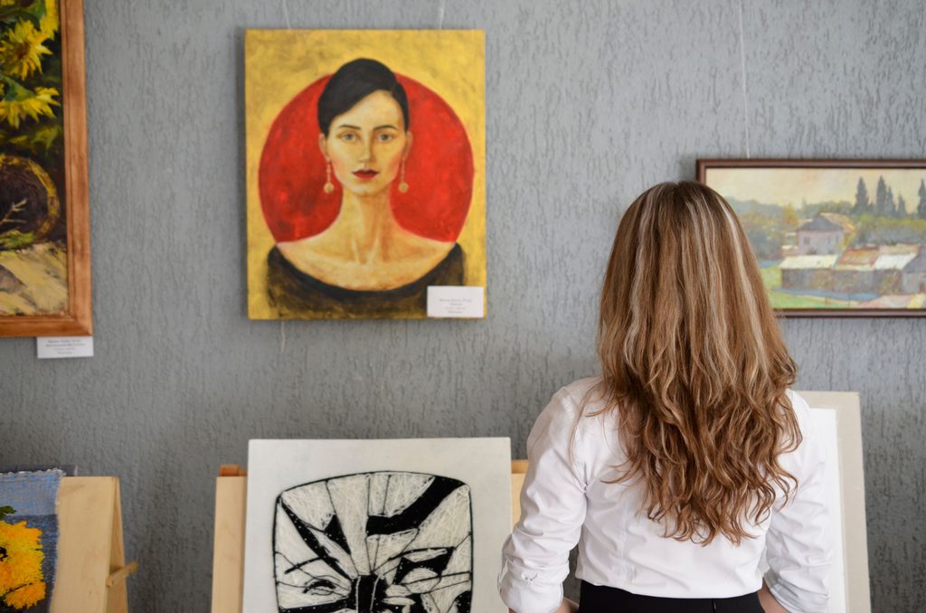 Femme observant des œuvres d’art dans une exposition